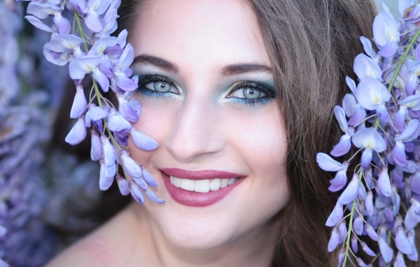 Улыбающаяся девушка с цветами глицинии
