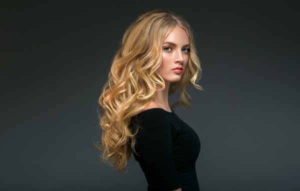 Стильная голубоглазая длинноволосая девушка в черном наряде