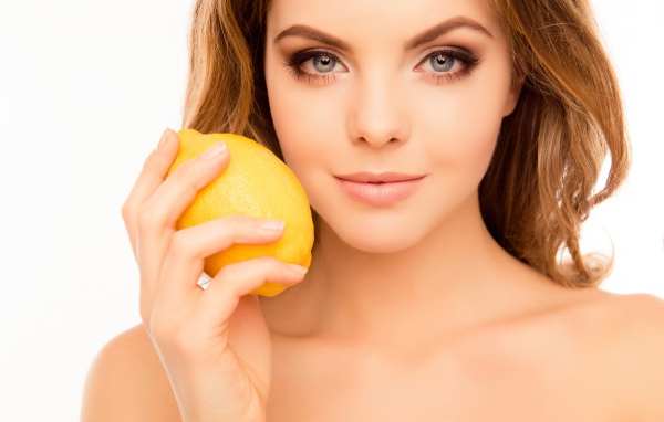 Нежная голубоглазая девушка с лимоном в руке