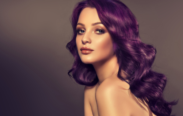 Девушка с фиолетовыми волосами на сером фоне