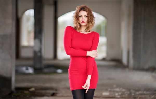 Молодая девушка в красном платье в старом здании