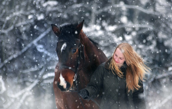 Молодая девушка с конем зимой 