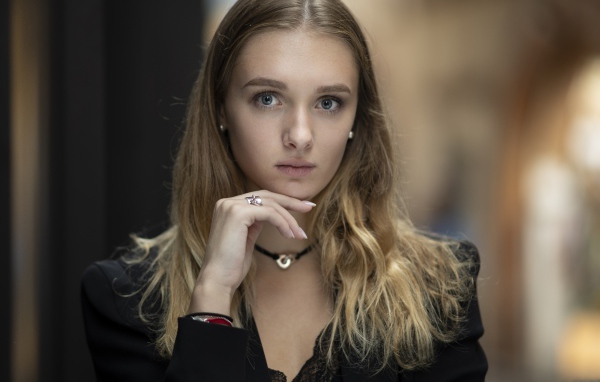 Молодая нежная голубоглазая девушка с рукой у лица