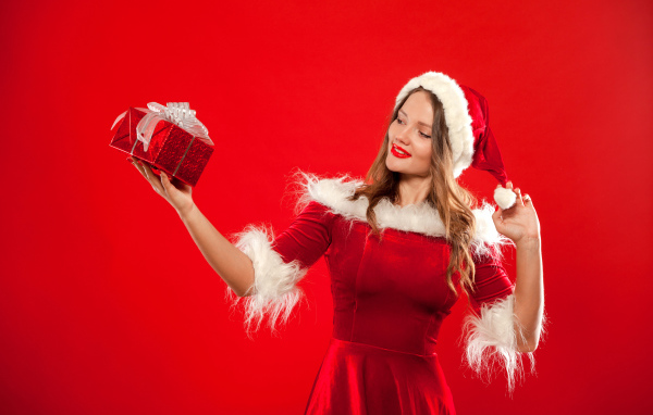 Beautiful Snow Maiden with a gift in her hand on a red background