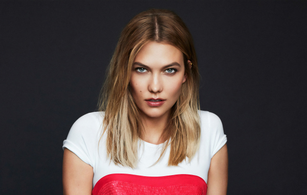 Красивая голубоглазая девушка модель Карли Клосс на сером фоне