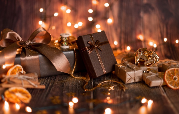 Много подарков на деревянном фоне с гирляндой