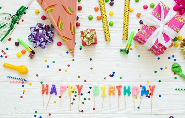 Надпись с Днем рождения на столе с подарками и украшениями