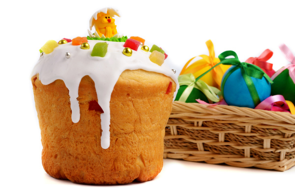 Красивый пасхальный кулич на белом фоне с корзиной крашеных яиц к празднику Пасха