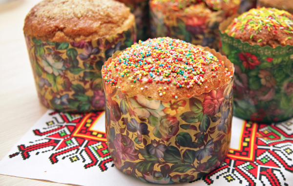 Вкусные сладкие куличи с посыпкой стоят на рушнике