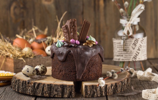Пасхальный кулич с шоколадной глазурью и сладостями на праздник Пасха