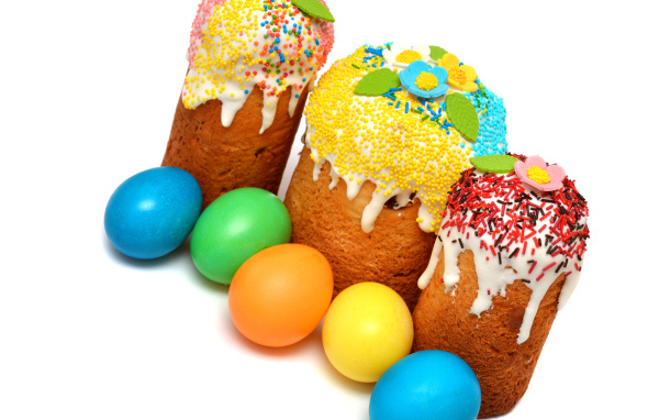 Три кулича с крашеными яйцами на белом фоне к празднику Пасха