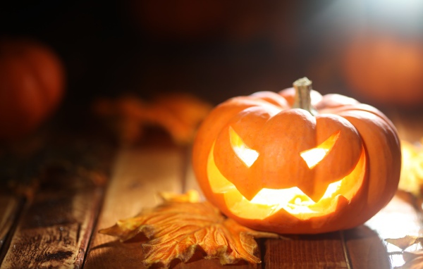 Светящаяся тыква на столе на Хэллоуин