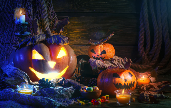 Зловещие тыквы на столе со сладостями на праздник Хэллоуин 