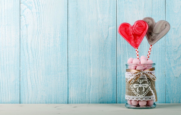 Банка с маршмеллоу и сердечками на голубом фоне