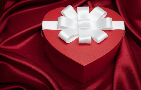 Большая красивая красная коробка в форме сердца с белым бантом