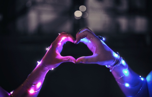 Девушка делает сердце руками