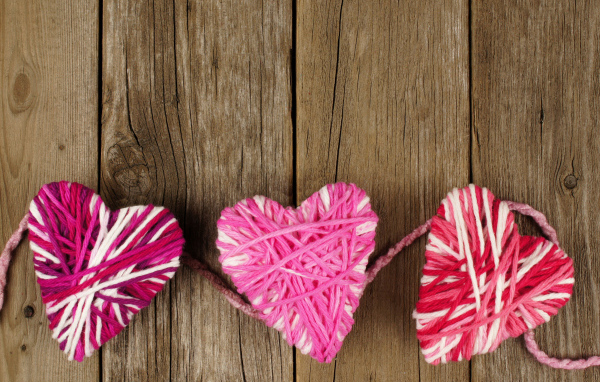 Сердца из ниток на деревянном столе