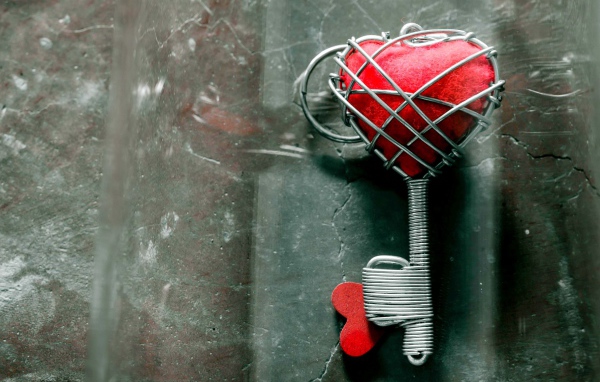 Ключ с красным сердцем на сером столе