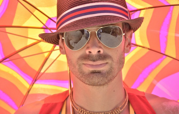 Мужчина в солнечных очках и шляпе летом