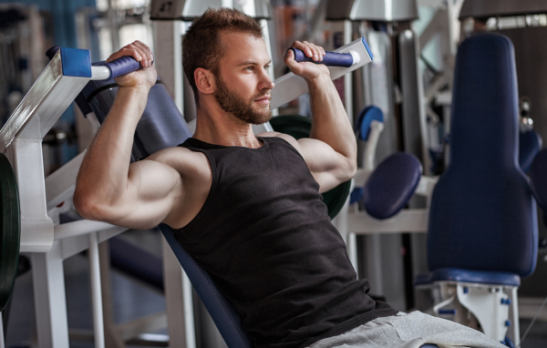 Накаченный мужчина занимается в спортзале