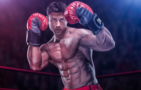 Спортивный мужчина боксер в перчатках на ринге