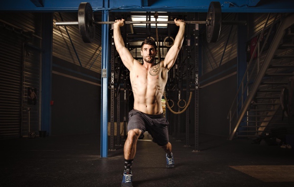 Спортивный мужчина со штангой в руках 