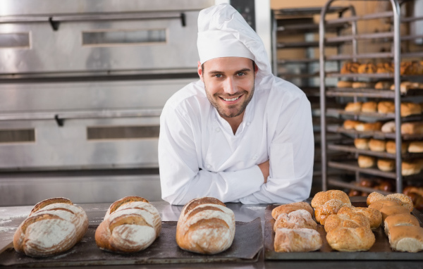 Красивый улыбающийся мужчина пекарь в форме