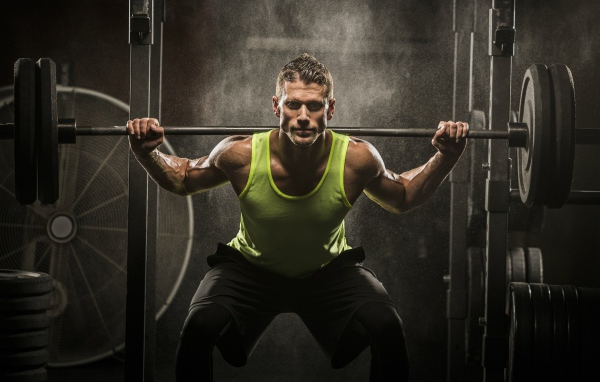 Мужчина спортсмен со штангой на плечах 