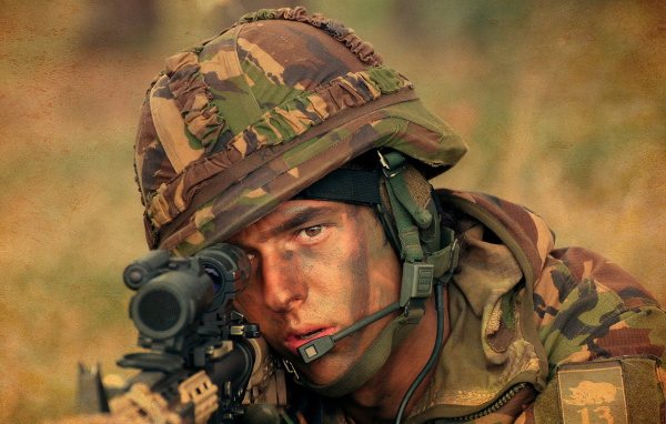 Мужчина солдат в каске с винтовкой