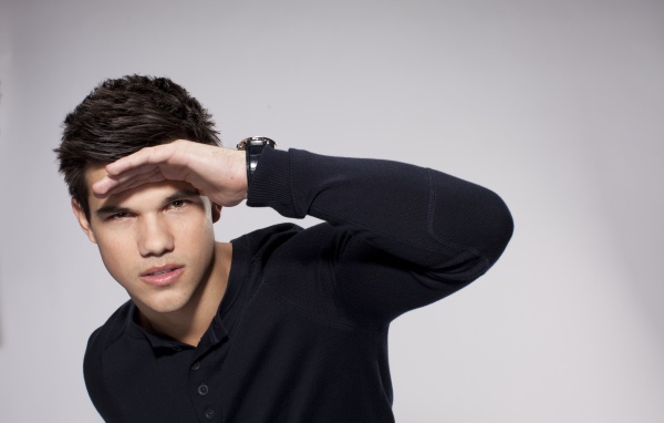 Красивый парень, актер Тейлор Лотнер на сером фоне