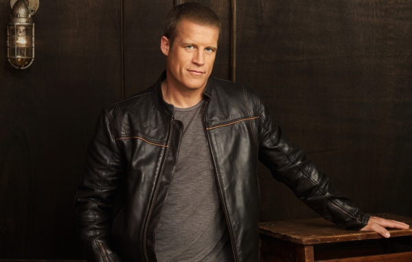 Красивый мужчина, актер Марк Вэлли в кожаной куртке