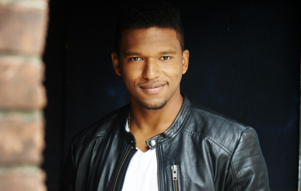 Красивый мужчина в черной куртке, актер Ловелл Адамс-Грей