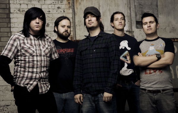 Музыкальная группа Funeral for a Friend стоят у старой стены