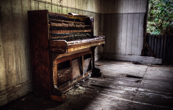 Old piano in the room of an abandoned house