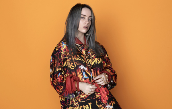 Певица Билли Айлиш на оранжевом фоне