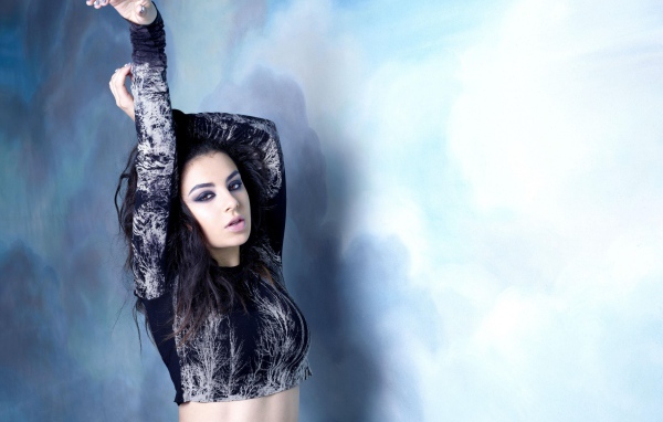 Молодая исполнительница Charli XCX  на голубом фоне