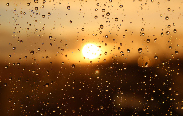 Капли дождя на стекле при свете солнца