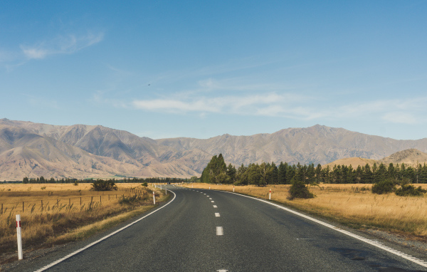 Ровная асфальтовая дорога на фоне гор 