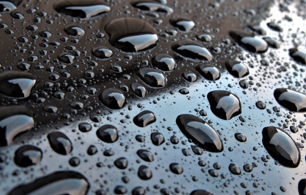 Капли воды на черной глянцевой поверхности 