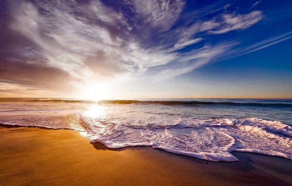 Красивые белые морские волны на теплом песке летом