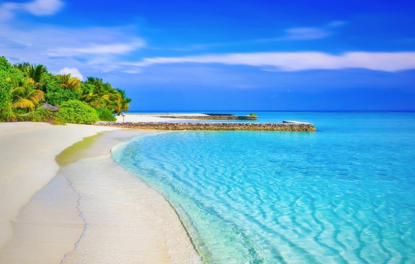 Чистая голубая вода океана на белом песке тропического пляжа