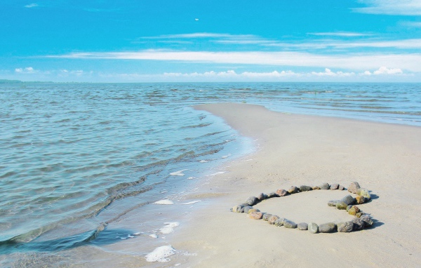 Сердце из камней на берегу теплого моря летом