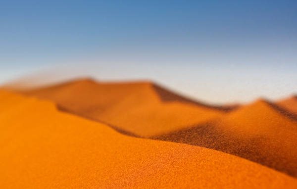 Желтый песок в пустыне под голубым небом