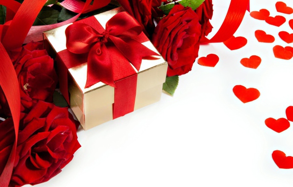 Подарок с красным бантом на белом фоне с красными розами и сердечками