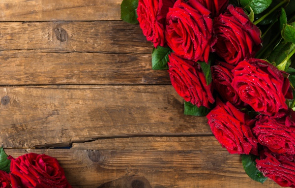 Красивый букет красных роз на деревянном фоне