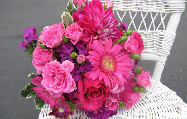 Букет с розовыми цветами георгины, розы, герберы и флоксы на белом стуле