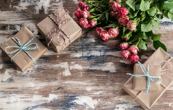 Подарочные коробки на деревянной поверхности с букетом роз