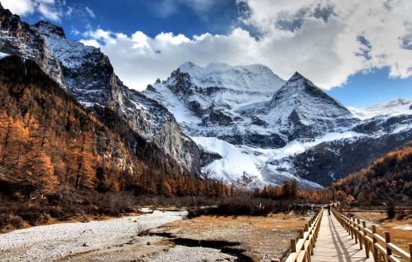 Мост у подножия заснеженных величественных гор