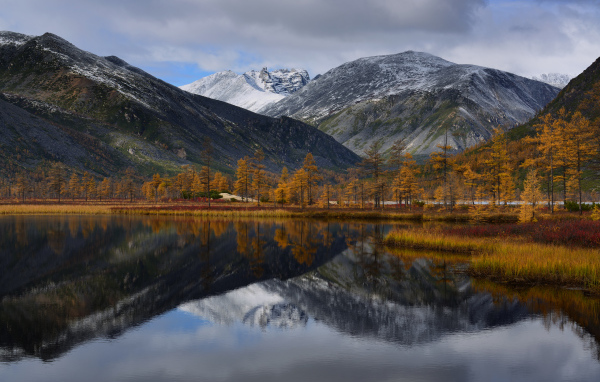 Горы отражаются в глади воды озера осенью
