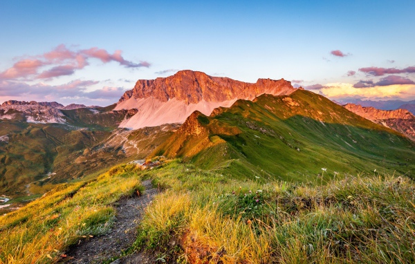 Солнце встает над зелеными горами